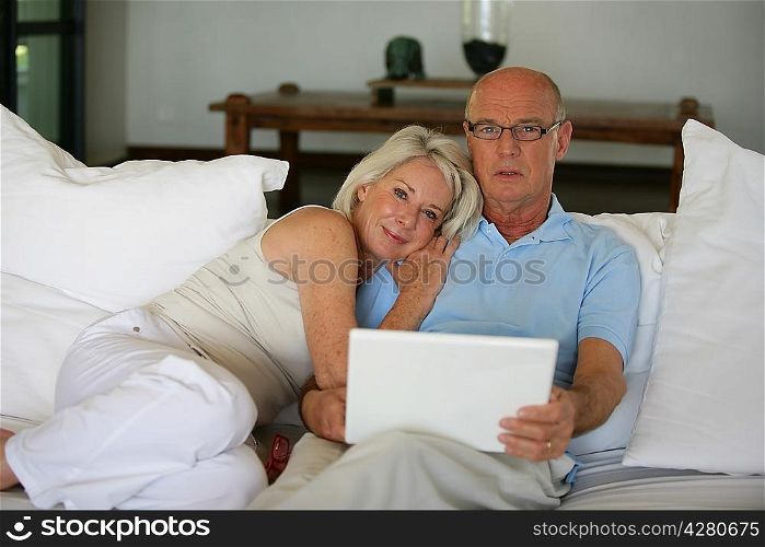 Senior couple on a sofa with laptop computer