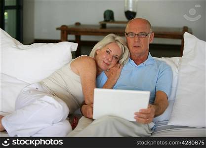 Senior couple on a sofa with laptop computer