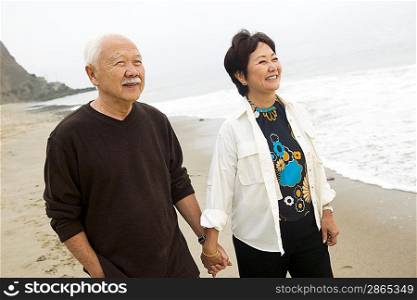 Senior couple on beach holding hands