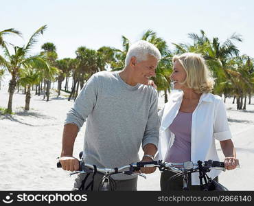 Senior couple on bicycles on tropical beach