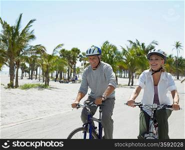 Senior couple on bicycles on tropical beach