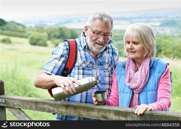 Senior Couple On Hike Having Hot Drink