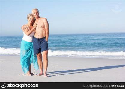 Senior Couple On Holiday Walking Along Sandy Beach