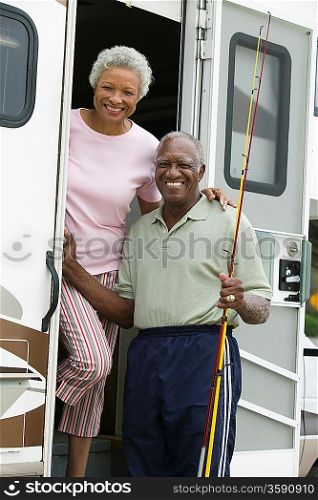Senior couple on steps of a caravan