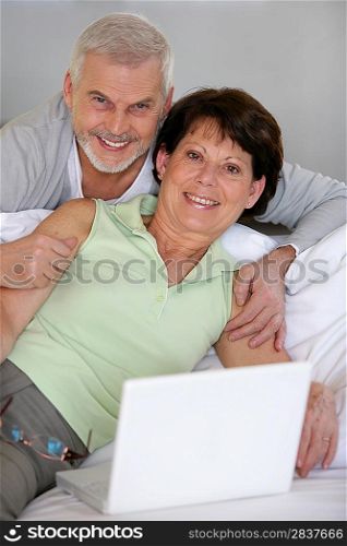 Senior couple on the sofa with a computer