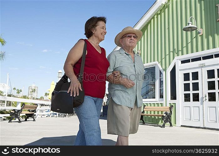 Senior couple on vacations, walking arm in arm