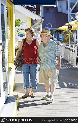 Senior couple on vacations watching window displays