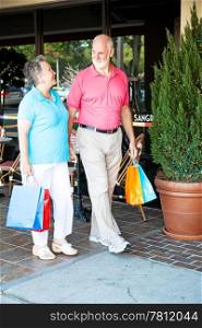 "Senior couple out shopping together. (word visible in window is just "sangria", not restaurant name or logo)"