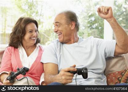 Senior Couple Playing Computer Game At Home