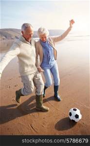 Senior Couple Playing Football On Winter Beach