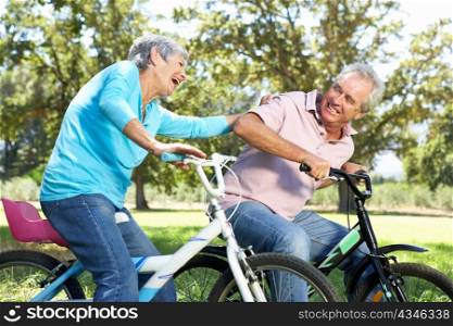 Senior couple playing on children&acute;s bikes