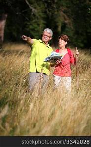 Senior couple rampling in countryside with map