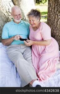 Senior couple reading e-mail on their smart phone.