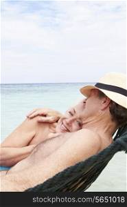 Senior Couple Relaxing In Beach Hammock