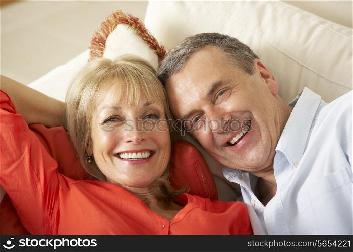 Senior Couple Relaxing On Sofa At Home
