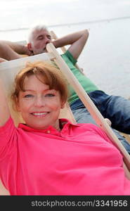 Senior couple resting in deck chairs