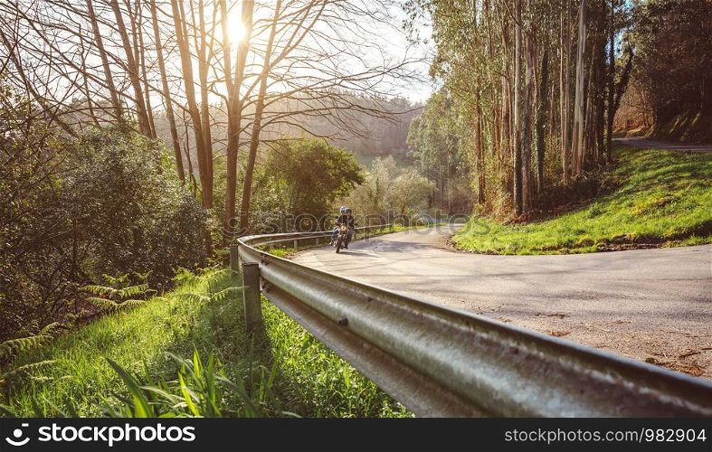 Senior couple riding a motorbike along forest road in autumn. Senior couple riding motorbike along forest road