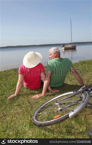 Senior couple riding bicycle in summer