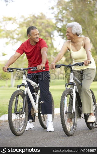 Senior Couple Riding Bikes In Park