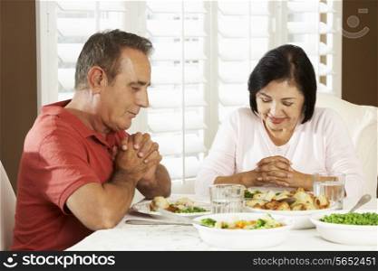 Senior Couple Saying Grace Before Meal At Home