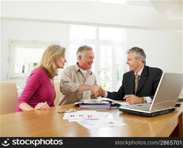Senior couple sitting at table with financial advisor
