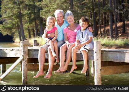 Senior couple sitting by lake with grandchildren