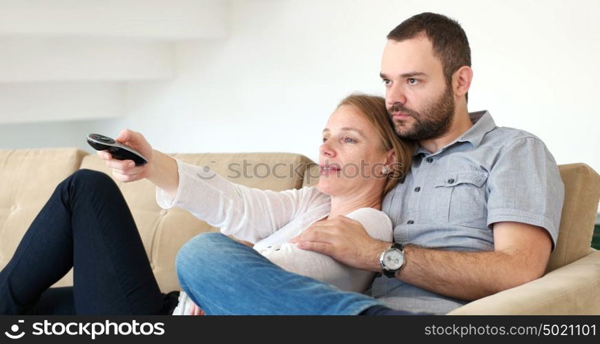 Senior couple sitting in couch and watching tv