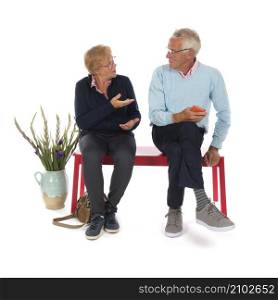 Senior couple sitting in waiting room isolated over white background
