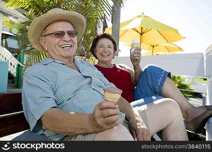 Senior couple sitting on bench and holding ice creams