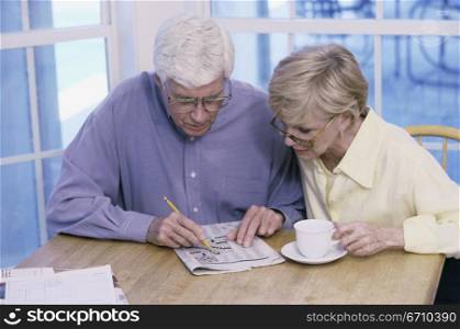 Senior couple solving a crossword puzzle