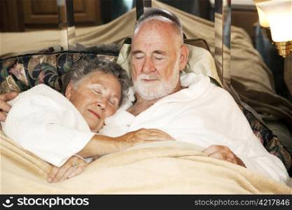 Senior couple sound asleep in the bed of their motor home.