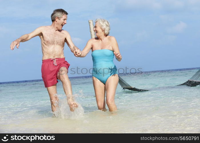 Senior Couple Splashing In Beautiful Tropical Sea