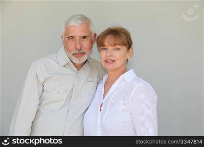 Senior couple standing on white background