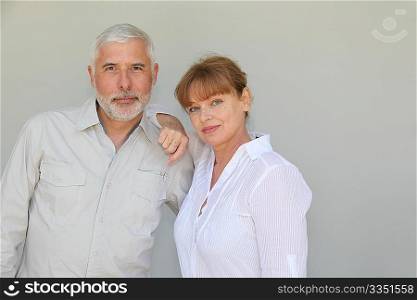 Senior couple standing on white background