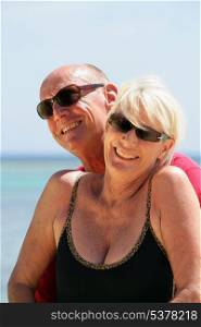 Senior couple stood on a secluded beach