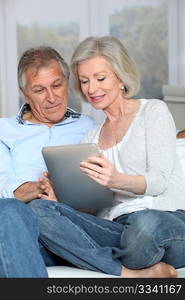 Senior couple surfing on internet with electronic tablet