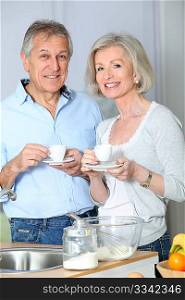 Senior couple taking coffee in kitchen