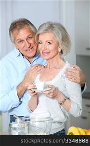 Senior couple taking coffee in kitchen