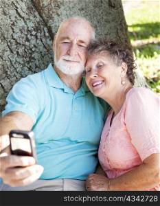 Senior couple taking their self-portrait with a cellphone camera.