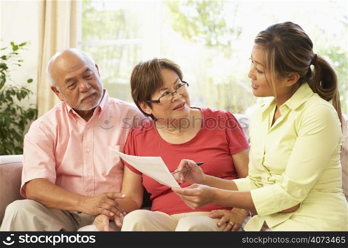 Senior Couple Talking To Financial Advisor At Home