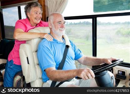 Senior couple traveling in their motor home. The husband is driving.