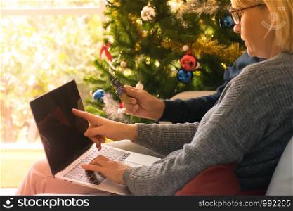 Senior couple using credit card and laptop computer to shop online.Shopping online at home.