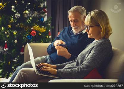 Senior couple using credit card and laptop computer to shop online.Shopping online at home.