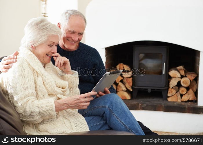 Senior Couple Using Digital Tablet On Sofa