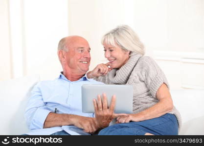 Senior couple using electronic tablet at home