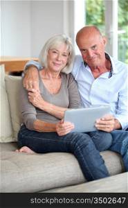 Senior couple using electronic tablet at home