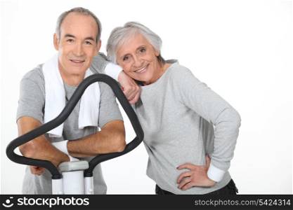Senior couple using gym equipment