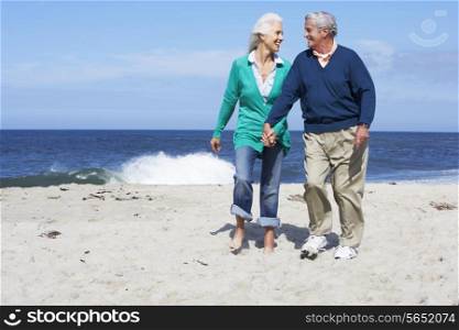 Senior Couple Walking Along Beach Together