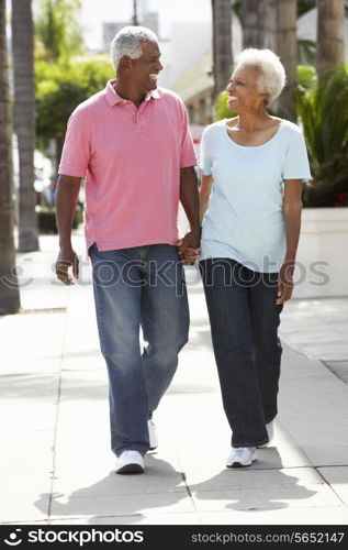 Senior Couple Walking Along Street Together