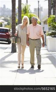 Senior Couple Walking Along Street Together